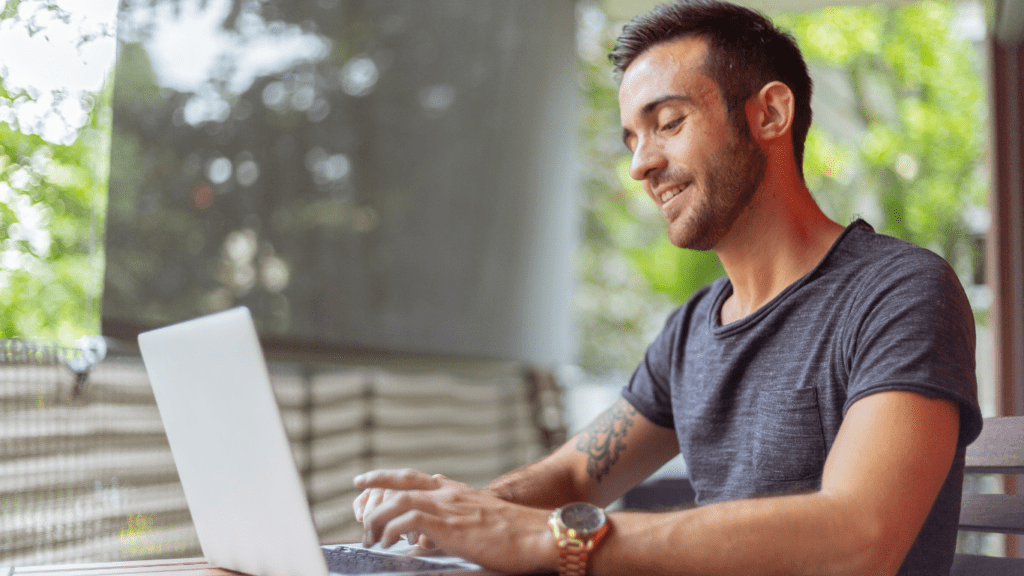 A person sitting at a table with a laptop