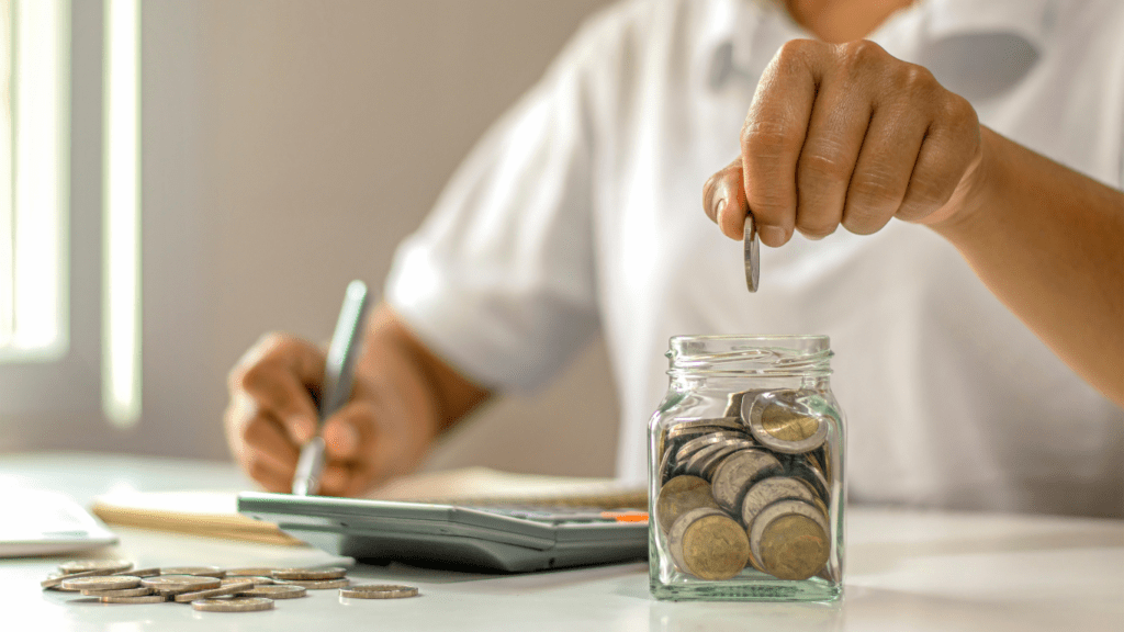 Putting coins in a jar on a table