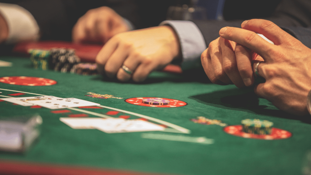 a person in a suit and tie playing cards at a casino table