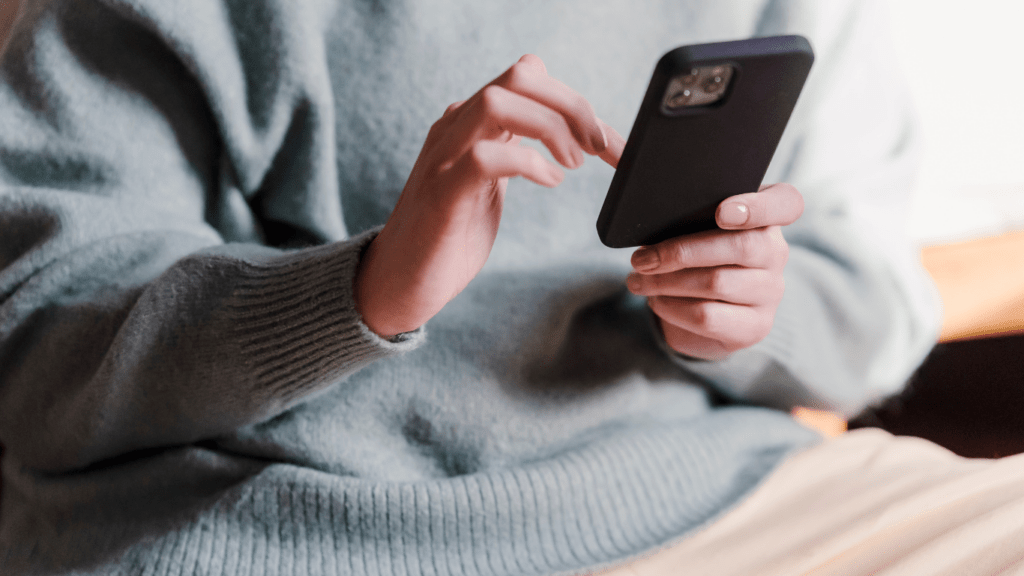 a person is using a cell phone while sitting on a couch