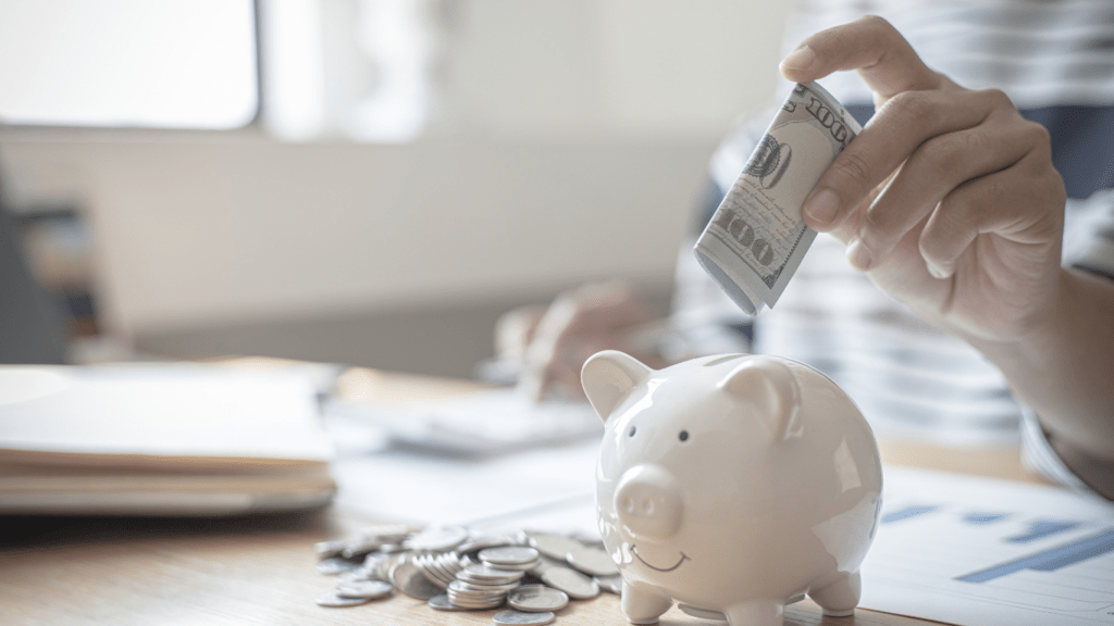 a person putting a money in a piggy bank