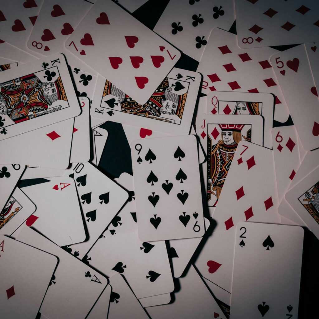 A scattered arrangement of playing cards showcasing various suits. Ideal for casino and card game themes.